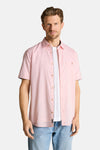 Chemise rose à manches courtes de Tom Tailor avec poche poitrine et liseré contrastant, portée ouverte sur un t-shirt blanc et un jean bleu.