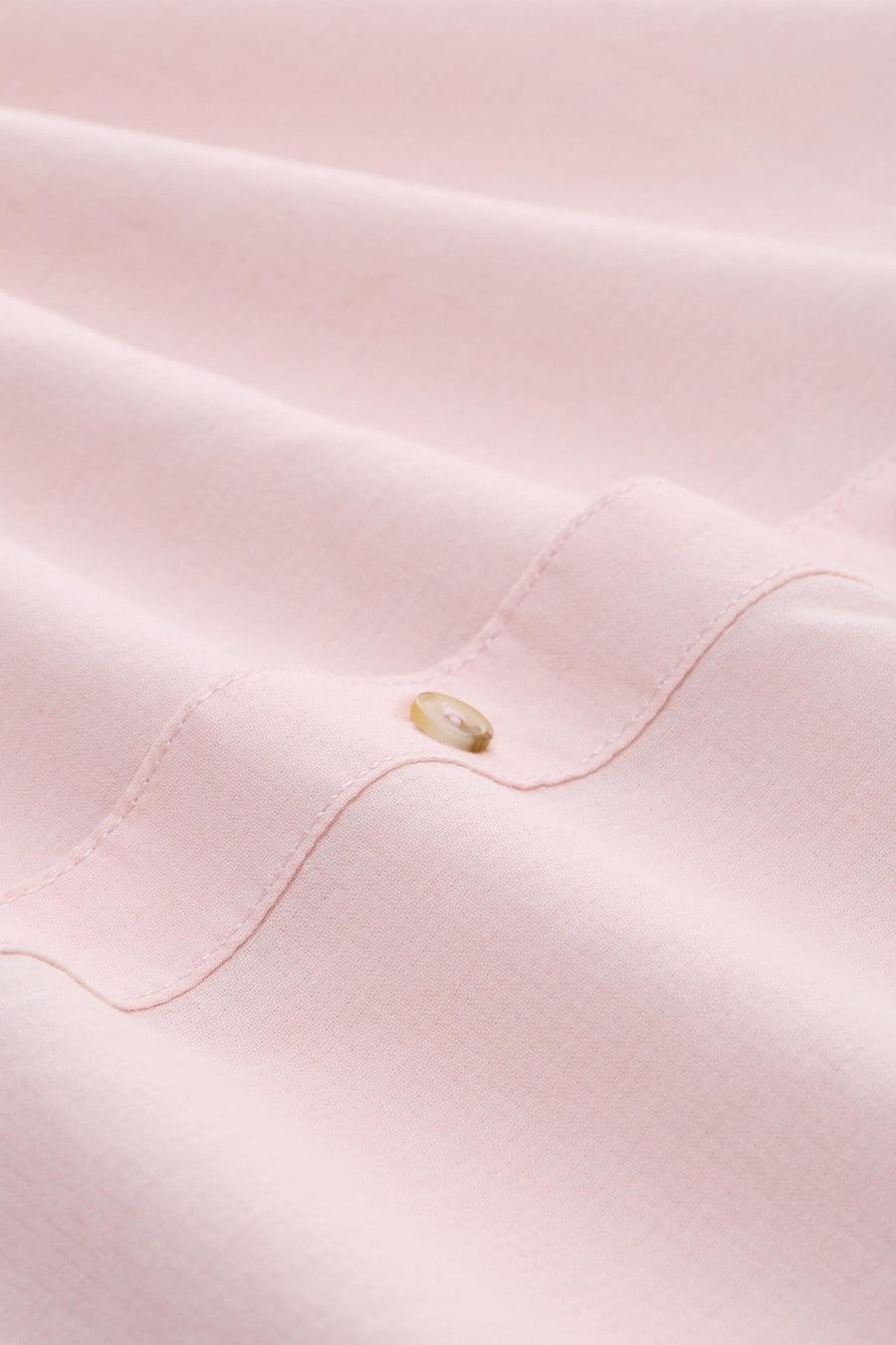 Chemise rose de Tom Tailor, gros plan sur le tissu texturé froissé avec un bouton clair.