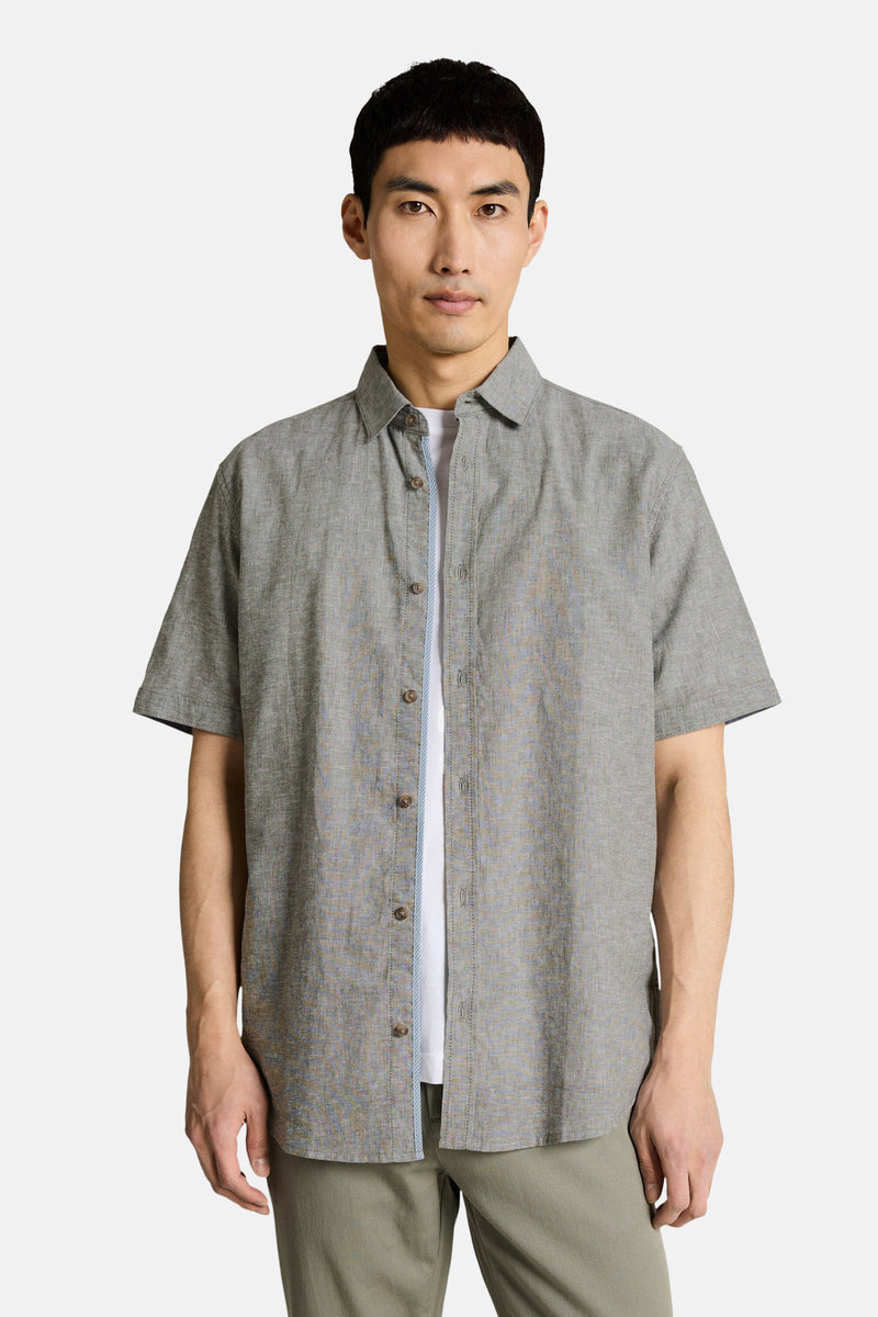 Kaki short-sleeve chemise with textured fabric and button-down front, worn over white tee, front view