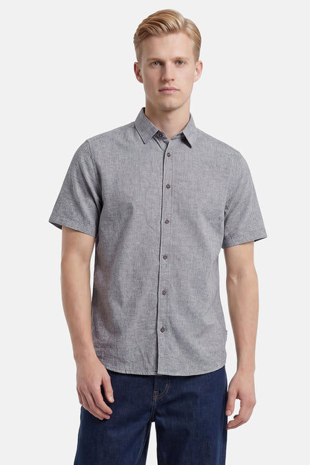 Chemise à manches courtes grise de Tom Tailor, en tissu texturé, boutonnée et portée avec un jean foncé.