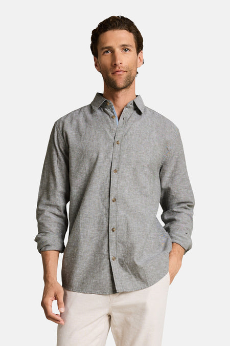 Chemise verte à manches longues de Tom Tailor, avec des boutons, porté avec un pantalon beige.