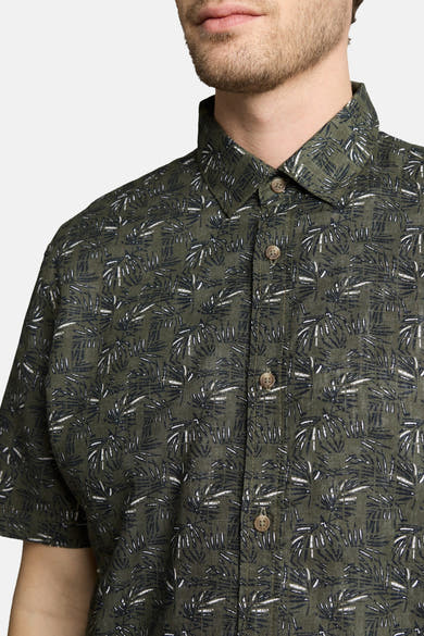 Groen overhemd met korte mouwen van Tom Tailor met palmbladpatroon, met knopen, gedragen door een man.