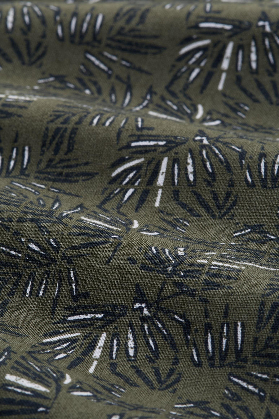 Groen overhemd met korte mouwen van Tom Tailor, close-up met donkere en witte abstracte bladerpatronen.
