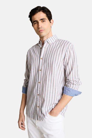 Chemise à manches longues multicolore de Tom Tailor, à rayures verticales avec poignets bleus, portée avec un pantalon blanc.