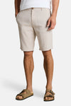 Bermuda beige par Tom Tailor, avec motif rayé vertical et porté avec des sandales marron.
