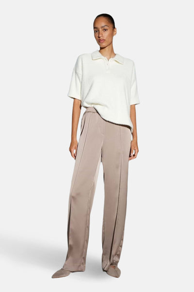 Pantalon taupe par OPUS, coupe ample avec détails de coutures le long des jambes.
