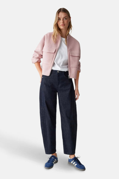 Pantalon en denim bleu foncé par OPUS, porté avec un t-shirt blanc et une veste rose.
