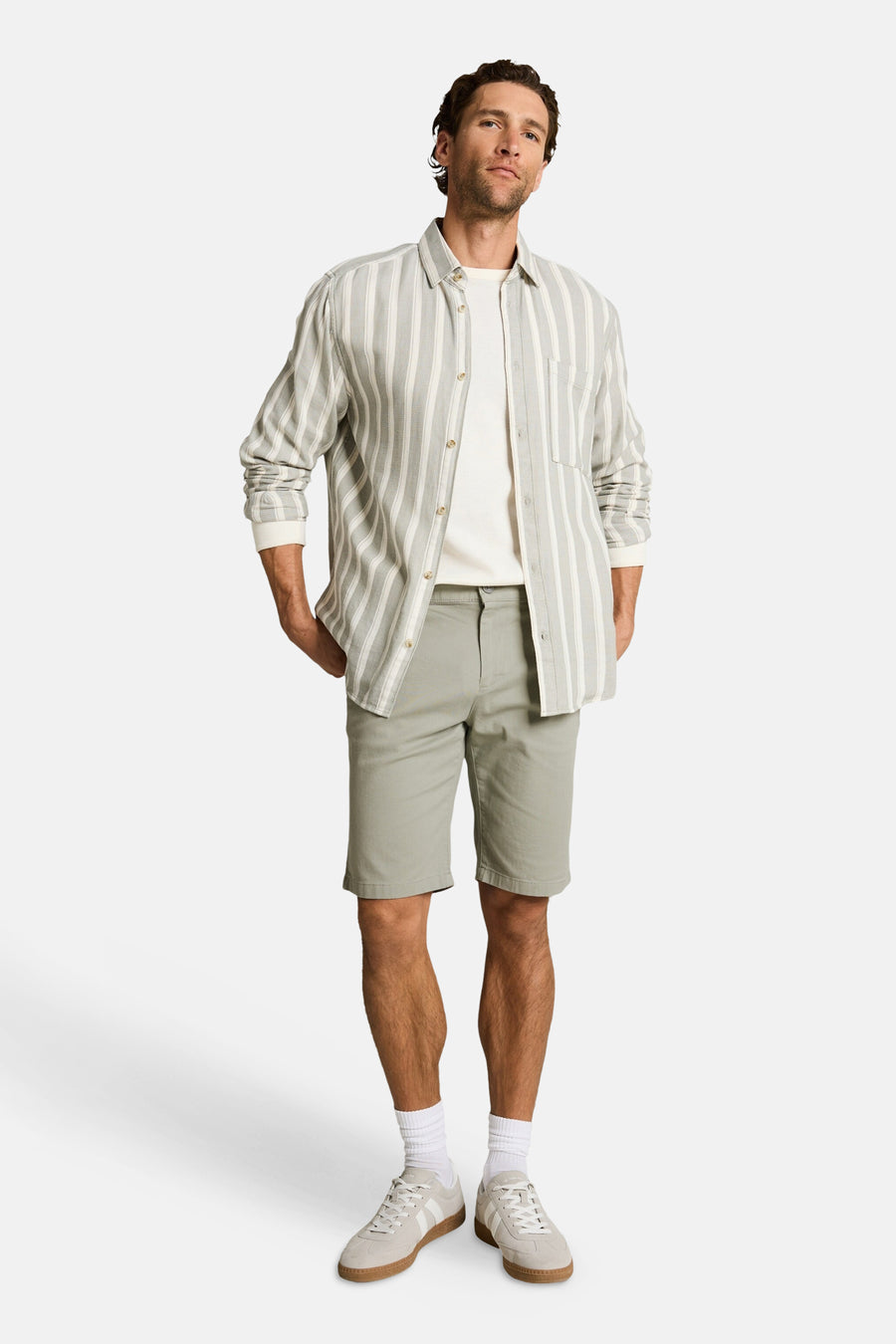 Short vert de Tom Tailor porté par un homme avec une chemise rayée et des baskets claires.
