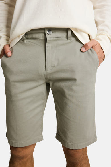 Short vert de Tom Tailor en sergé, avec bouton gris et poches, porté par un homme avec un pull blanc texturé.