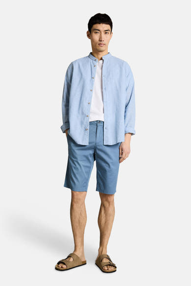 Bermuda bleu de Tom Tailor, porté avec une chemise bleue en lin et un t-shirt blanc.