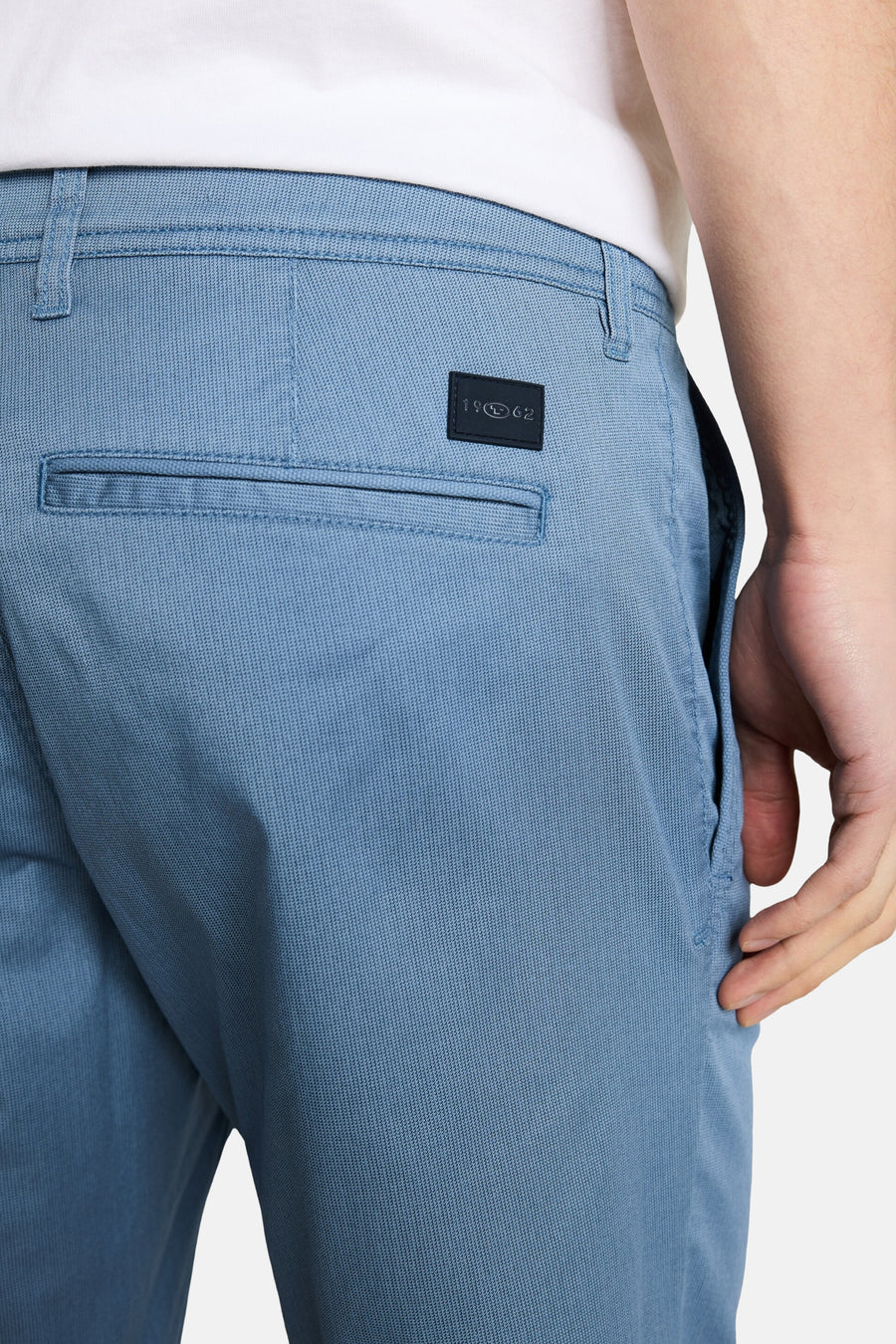 Bermuda bleu en tissu texturé de Tom Tailor, poche arrière passepoilée et patch logo noir.