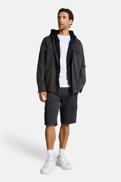 Short bleu par Tom Tailor, porté avec un t-shirt blanc, un blouson et des baskets blanches.