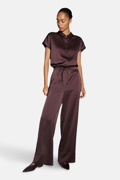 Combinaison bordeaux en satin par OPUS, avec chemisier à manches courtes boutonnée et pantalon à taille élastique.
