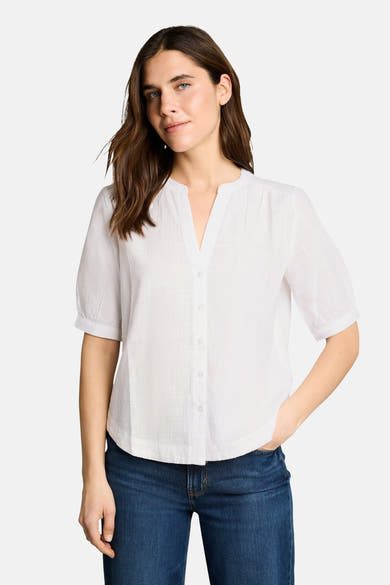 Wit blouse met korte mouwen van Tom Tailor, V-hals, geknoopt, gedragen met een wijde jeans en een beige tas.