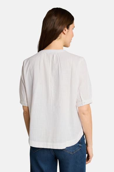 Wit blouse met korte mouwen van Tom Tailor in getextureerde stof, geplooid aan de achterkant, gedragen met een spijkerbroek.