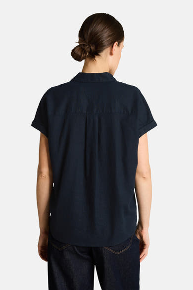 Chemisier à manches courtes bleu de Tom Tailor, vue de dos, coupe fluide avec manches retroussées, porté avec un jean foncé.