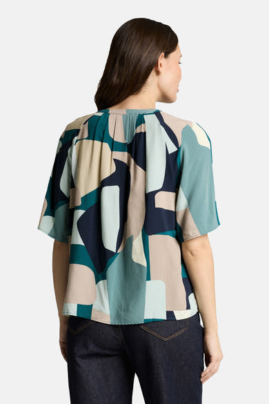 Chemisier à manches courtes multicolore de Tom Tailor, motif géométrique, porté avec un jean bleu foncé, vue de dos.
