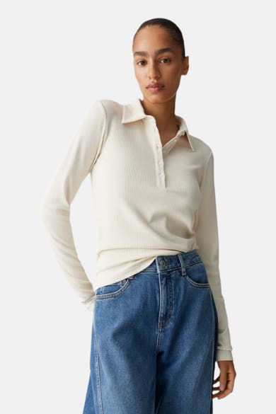 T-shirt beige à manches longues d'OPUS, en maille côtelée, porté avec un jean taille haute bleu.
