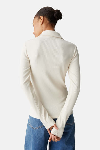 T-shirt beige à manches longues de OPUS, en maille côtelée, porté avec un jean.