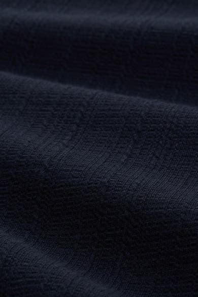 Robe bleue de Tom Tailor en tissu texturé foncé avec des plis subtils.