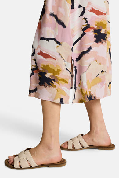 Multikleed van Tom Tailor met abstracte patronen en split, gedragen met beige sandalen.