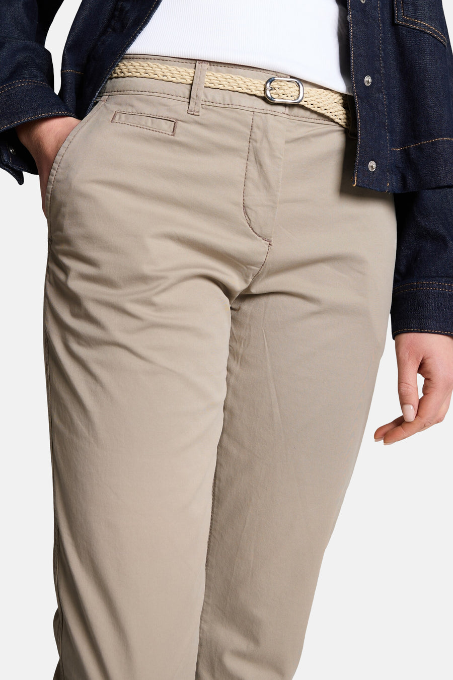 Chino beige de Tom Tailor, porté avec une ceinture tressée et une veste en jean foncée.
