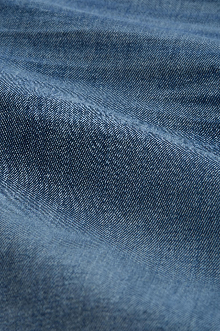 Short en jeans bleu denim de Tom Tailor, gros plan sur le tissu sergé et ses plis.