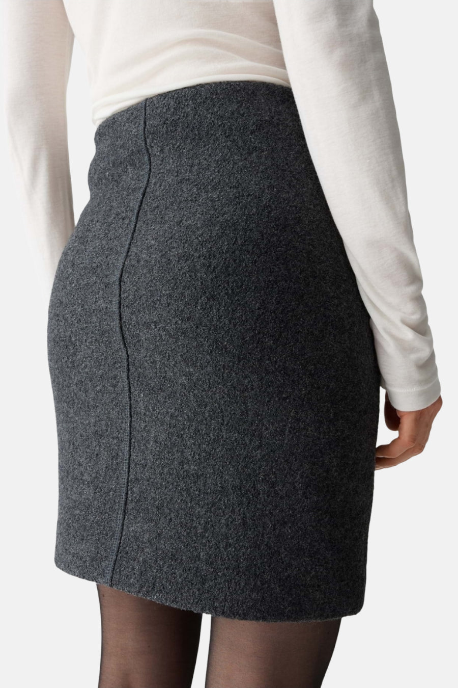 Korte grijze vilten rok van OPUS, van achteren gezien met een verticale naad en gedragen met een zwarte panty.