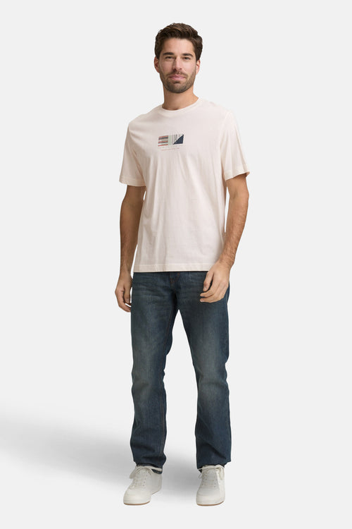 T-shirt à manches courtes blanc de Tom Tailor, avec un motif géométrique sur le devant, porté avec un jean et des baskets.
