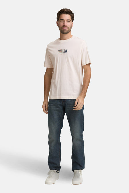 T-shirt à manches courtes blanc de Tom Tailor, avec un motif géométrique sur le devant, porté avec un jean et des baskets.
