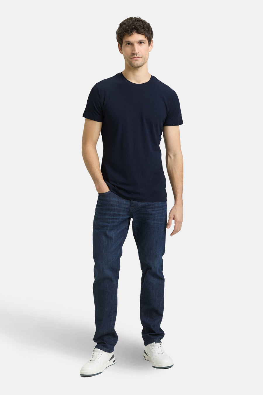 T-shirt à manches courtes bleu de Tom Tailor, porté avec un jean bleu foncé et des baskets blanches.