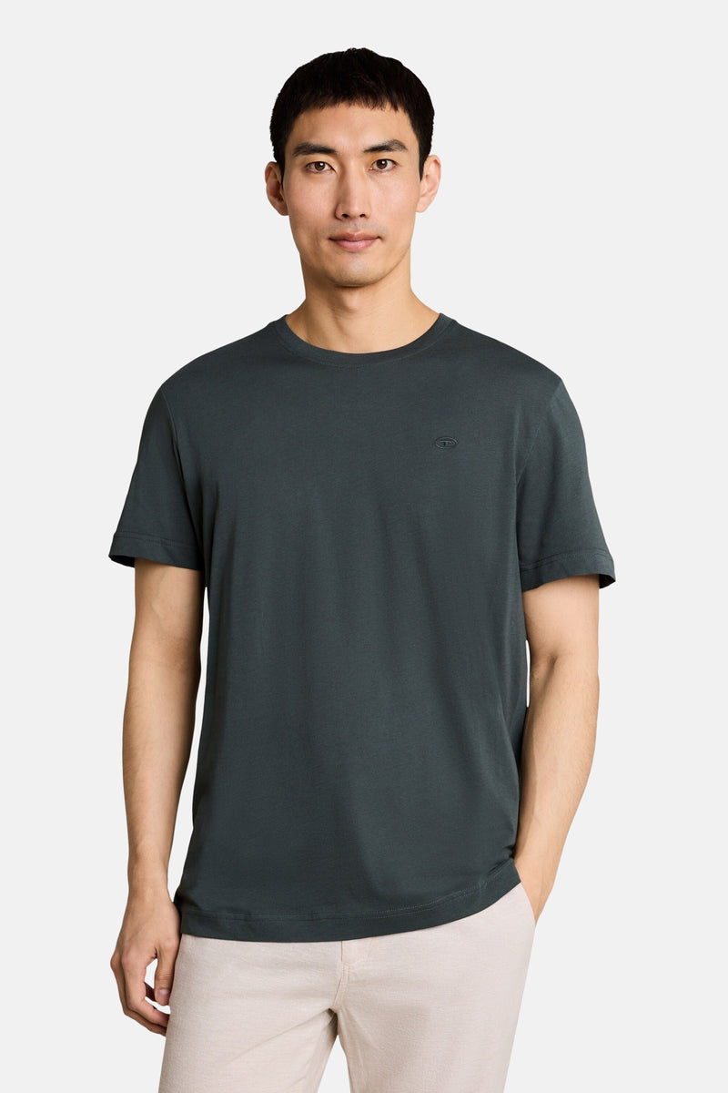 Olive short-sleeve t-shirt with ribbed crew neck and small chest logo, worn by model in front view with beige pants