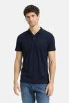 Blauw poloshirt met korte mouwen van Tom Tailor, gedragen met een spijkerbroek en witte sneakers.