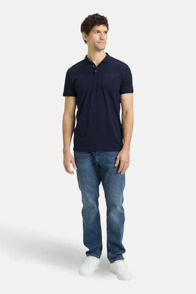 Polo bleu à manches courtes de Tom Tailor, porté avec un jean et des baskets blanches.