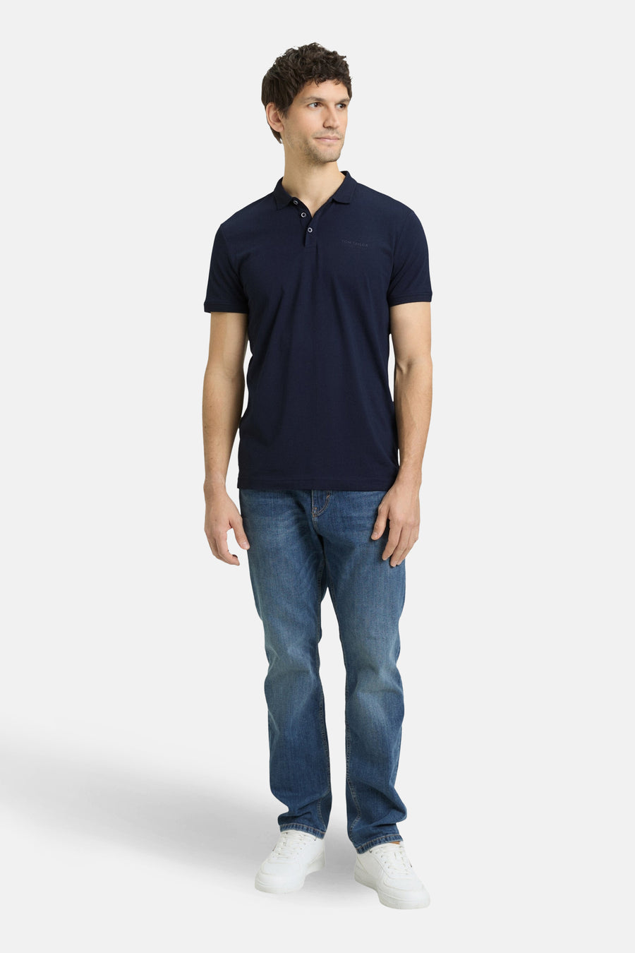 Polo bleu à manches courtes de Tom Tailor, porté avec un jean et des baskets blanches.