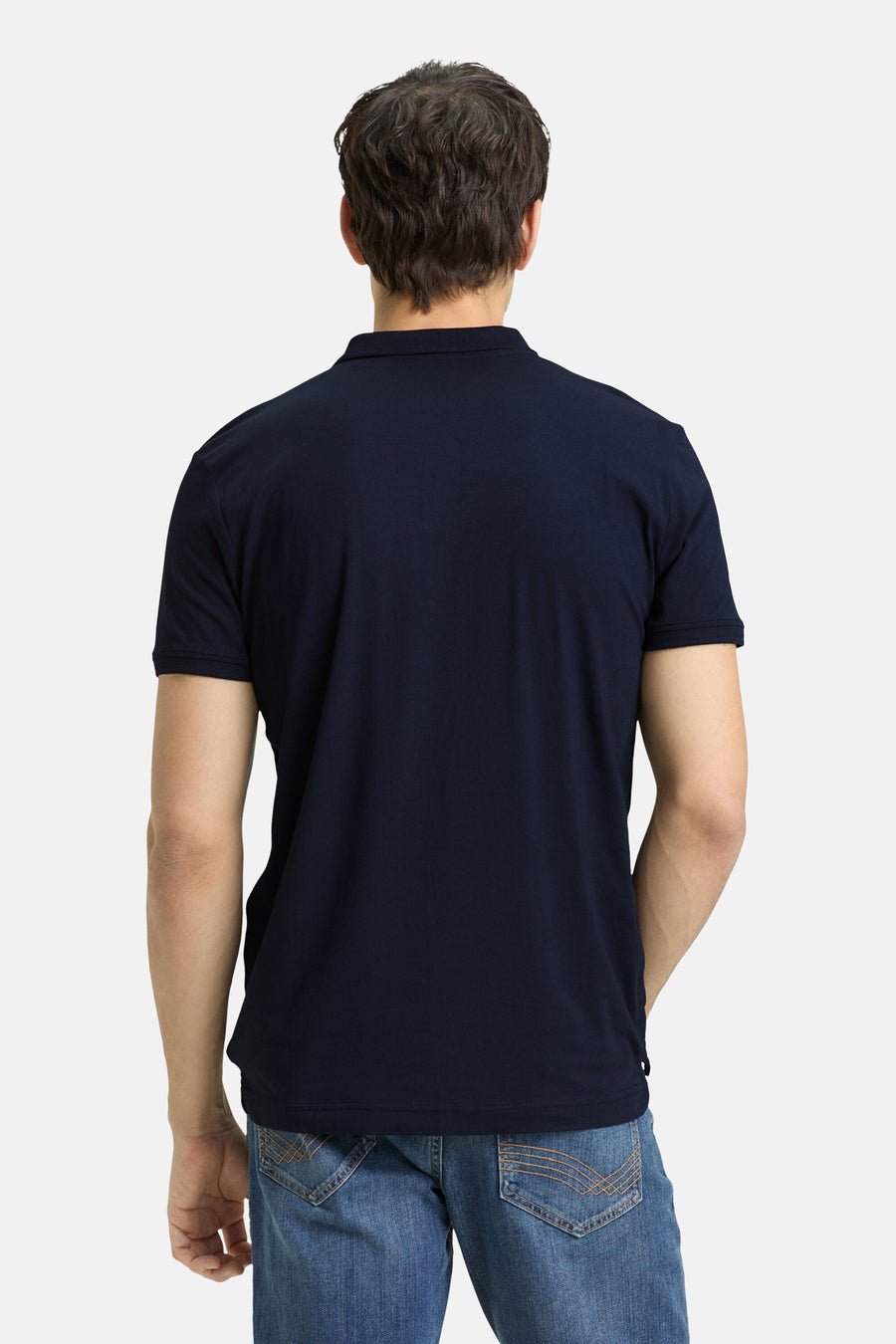 Blauw poloshirt met korte mouwen van Tom Tailor, met een man die een spijkerbroek draagt.
