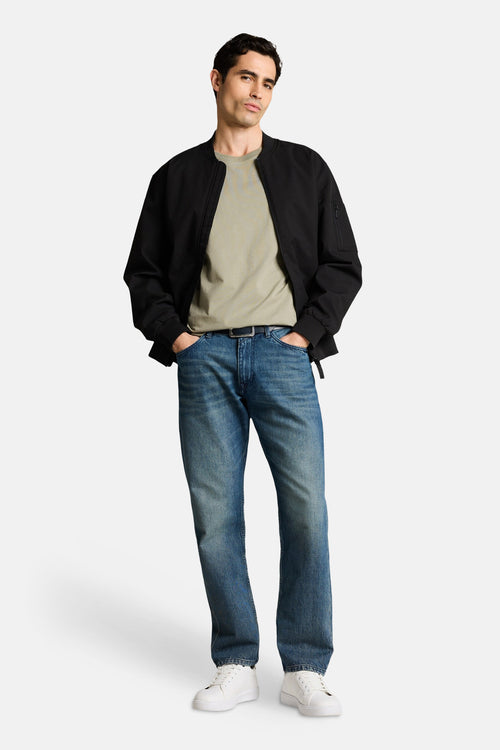 T-shirt kaki à manches courtes de Tom Tailor, porté avec une veste noire et un jean bleu.