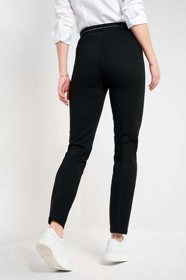 Pantalon noir de RAPHAELA, coupe droite, porté avec une chemise blanche et des baskets blanches, vue de dos.
