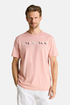 Roze T-shirt van Tom Tailor met TOM TAILOR-opschrift met patroon, gedragen door een man in een witte korte broek.