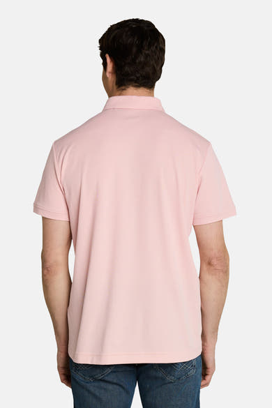 Polo rose pâle de Tom Tailor, en tissu piqué, porté de dos par un homme en jean.