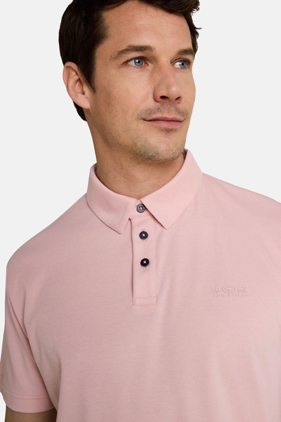 Polo rose de Tom Tailor avec col classique, trois boutons foncés et logo brodé sur la poitrine.
