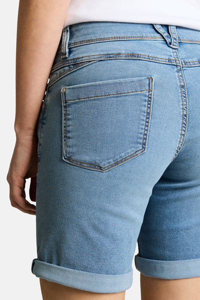 Bermuda en jean bleu clair de Tom Tailor, vue de dos, avec poche arrière et ourlets retroussés, porté avec un haut blanc.