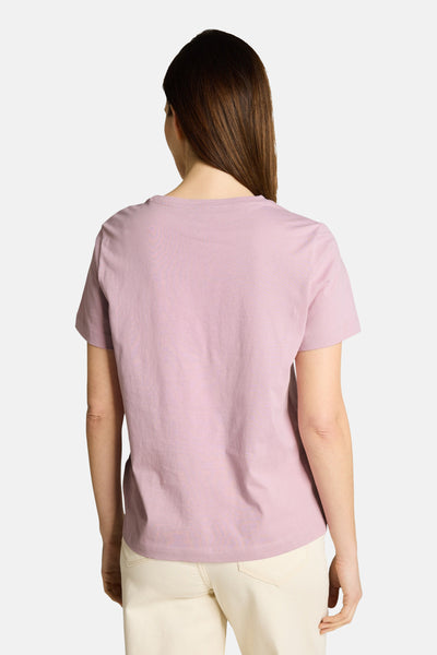 Top uni à manches courtes rose de Tom Tailor, vue de dos sur un mannequin portant un pantalon clair.