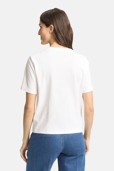 T-shirt blanc uni manche courte de Tom Tailor, vu de dos, porté avec un pantalon bleu.
