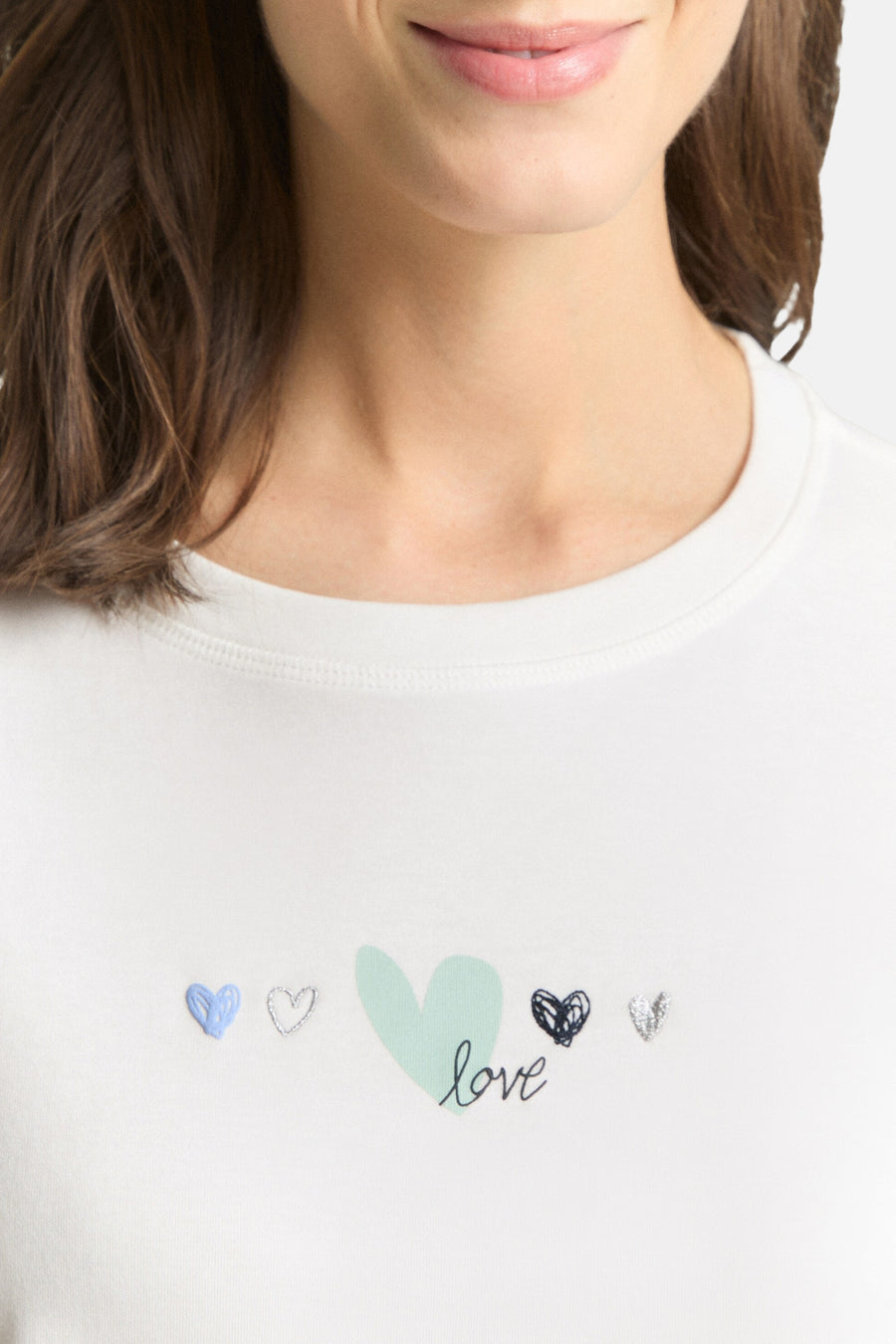 T-shirt blanc de Tom Tailor, orné de motifs de cœurs et du mot « love », porté par une femme.