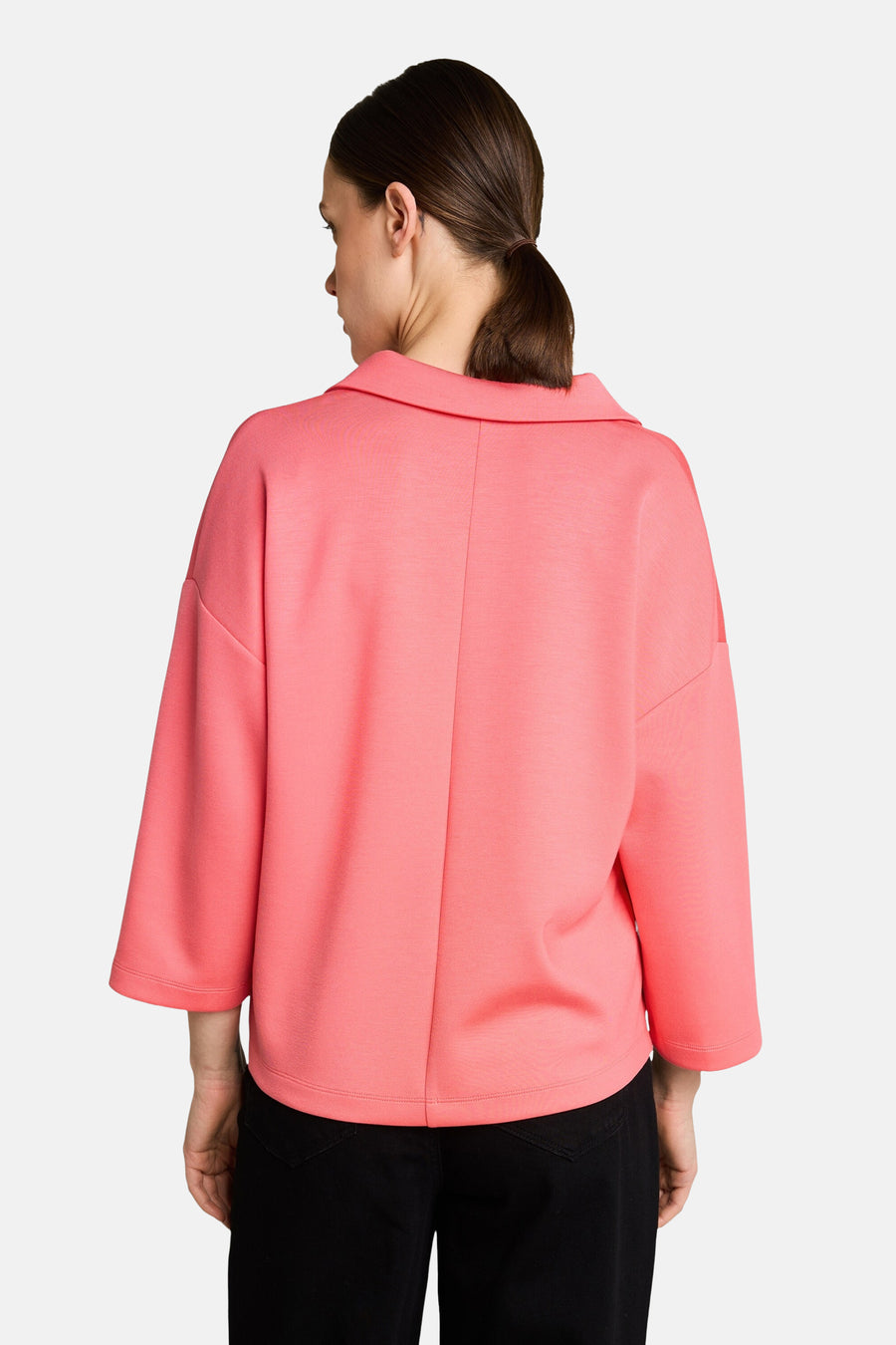 Polo corail de Tom Tailor, vue arrière, porté avec un pantalon noir décontracté, manches trois-quarts.