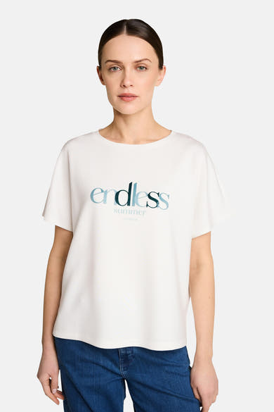 T-shirt blanc de Tom Tailor avec motif "endless summer" en dégradé de bleu, manches courtes et col rond, porté avec un jean.