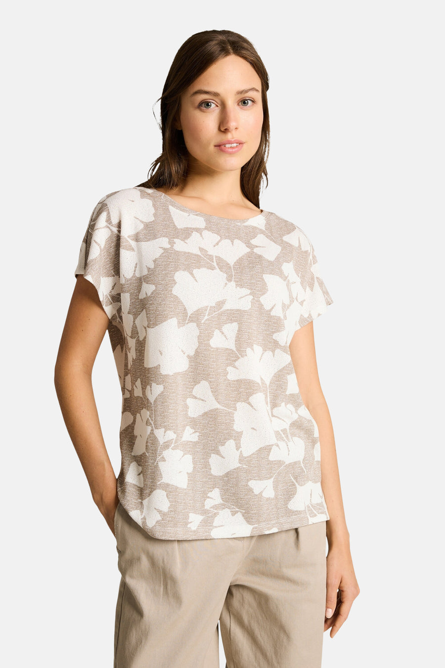 T-shirt beige à motif feuilles par Tom Tailor, porté avec un pantalon beige.