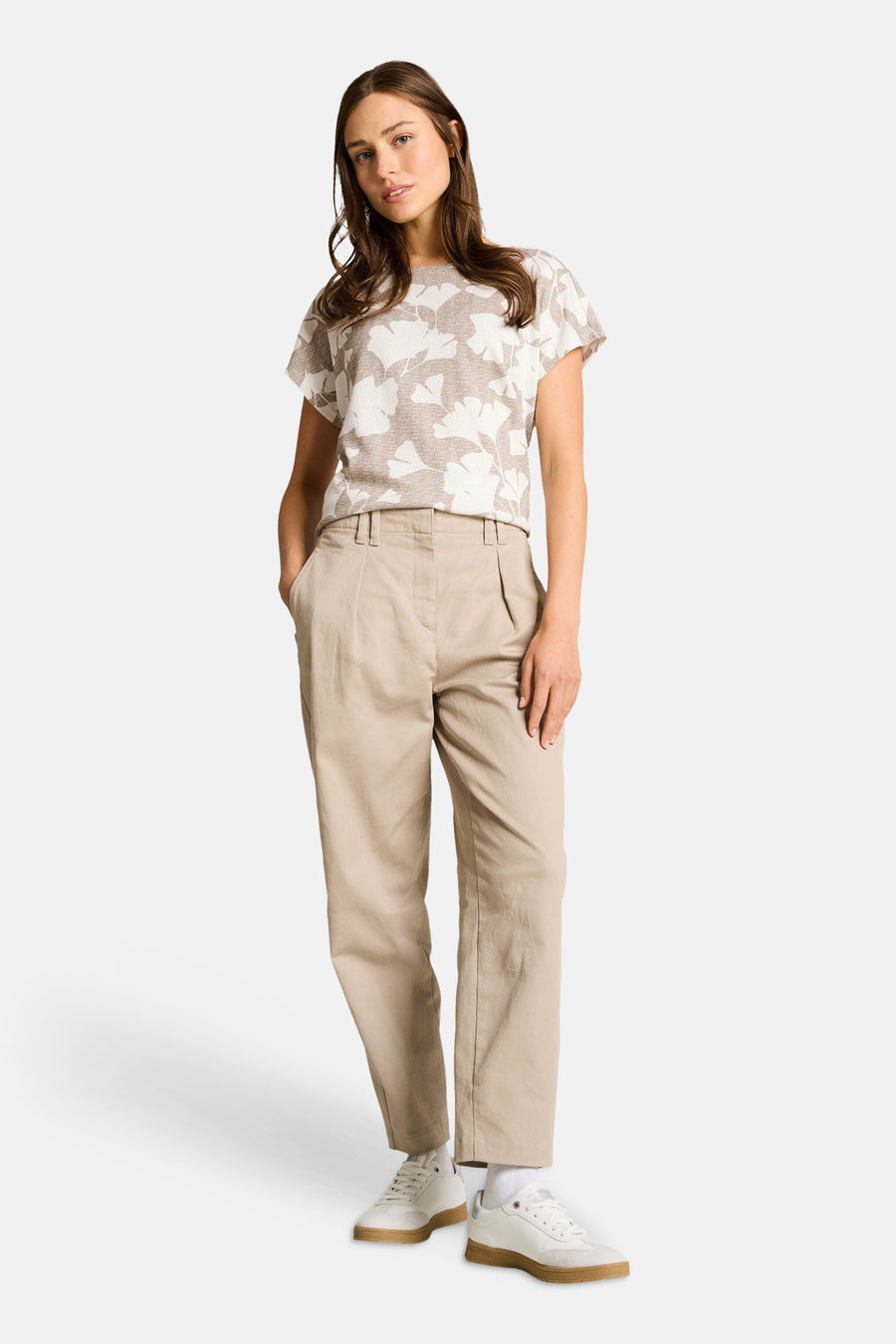 T-shirt beige à motifs floraux de Tom Tailor, porté avec un pantalon chino beige et des baskets blanches.