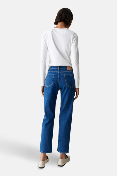Jean skinny en denim bleu moyen par OPUS, vu de dos, porté avec un haut blanc à manches longues.